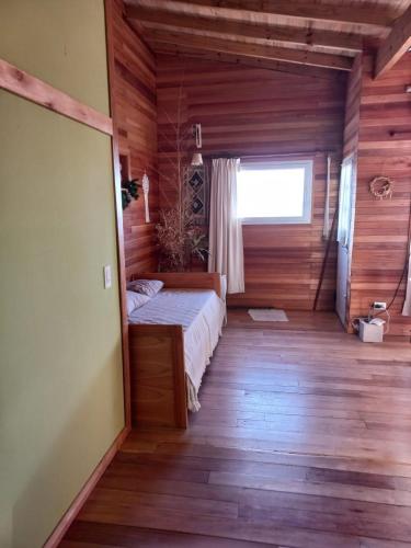 a bedroom with a bed in a wooden house at casa estilo cabaña in Tandil