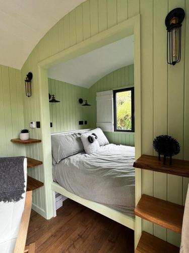 a bedroom with a bed with a large mirror at Hettie Luxury shepherds hut in Semley