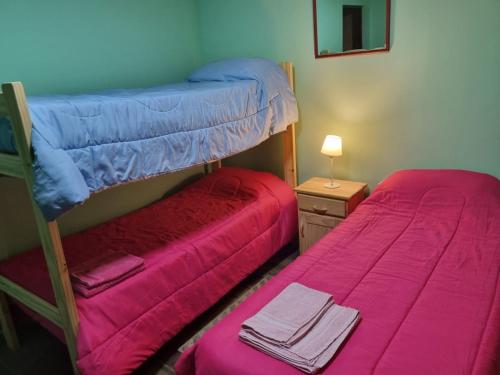 a bedroom with two bunk beds and a red bed at Polo Austral in Ushuaia