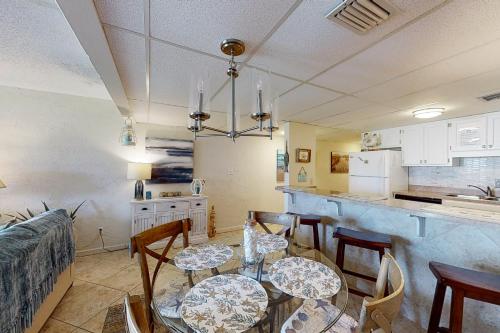 a dining room with two tables and a kitchen at Sugar Beach E5 in Panama City Beach