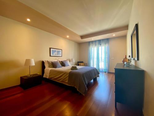 a bedroom with a bed and a dresser in it at Baia da Luz - Nuzone Apartment in Luz