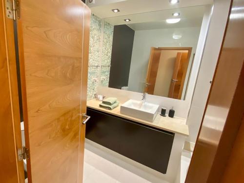 a bathroom with a sink and a mirror at Baia da Luz - Nuzone Apartment in Luz