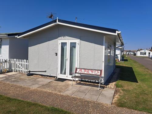 a small house with a bench in front of it at Beside the Sea Chalet, Mablethorpe in Mablethorpe