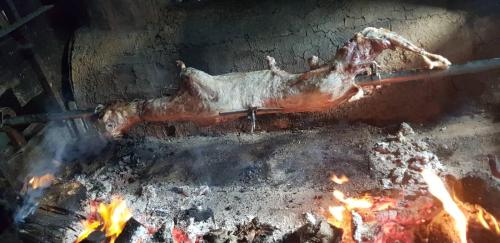 a piece of meat is cooking over a fire at Home of nature - kuća prirode in Odžak