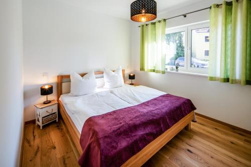 a bedroom with a large bed with a purple blanket at Chalet Altalmrich in Naumburg