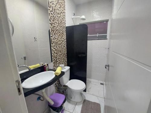 La petite salle de bains est pourvue d'un lavabo et de toilettes. dans l'établissement Bela Casa Piscina Aquecimento Solar em Americana-SP, à Americana