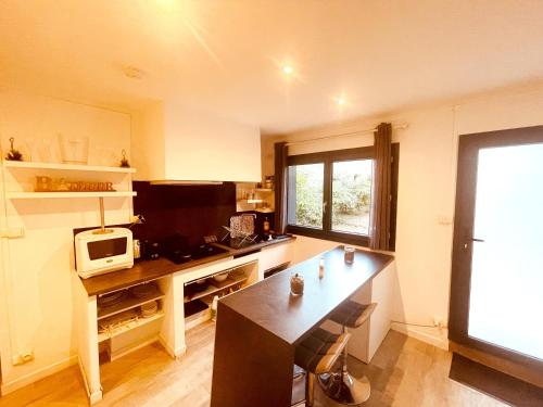 eine kleine Küche mit einem Schreibtisch und einer Mikrowelle in der Unterkunft Superbe appartement Boheme dans les vignes in Nîmes