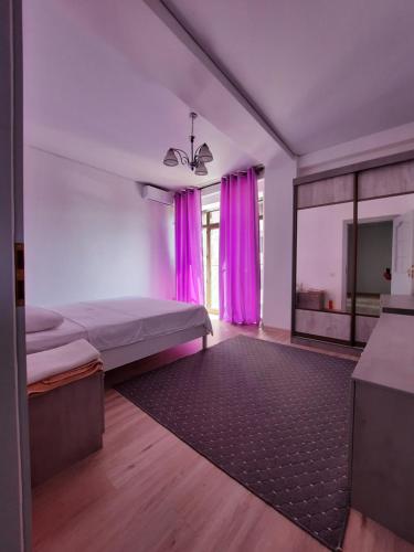 - une chambre avec des rideaux roses et un lit avec un tapis dans l'établissement Diplomat 3, à Bishkek