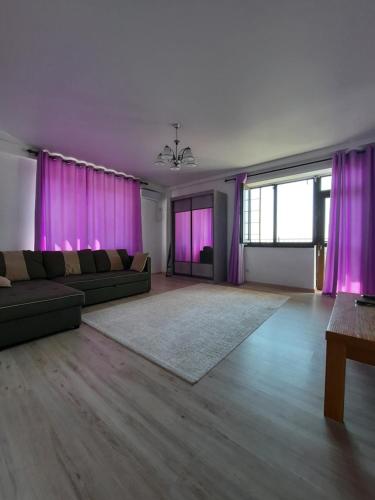 a living room with purple curtains and a couch at Diplomat 3 in Bishkek