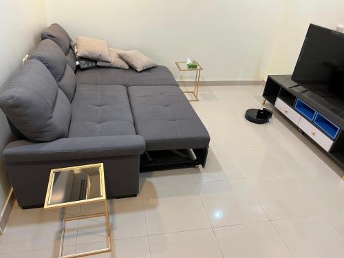 sala de estar con sofá y TV en نزل الفيحاء en Riad