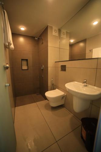 a bathroom with a toilet and a sink at Hotel Bekal International in Kāsaragod