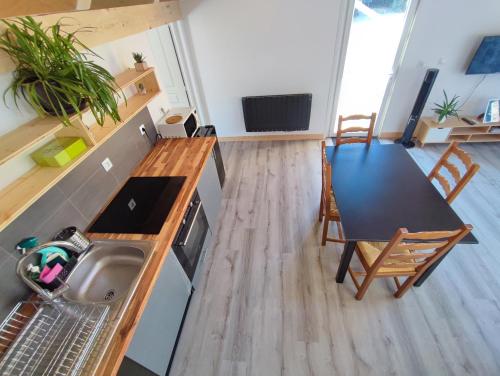 a kitchen with a sink and a table with a table at Petit Coin de Bonheur studio Neuf et lumineux à 5mins du Centre-ville in La Mure