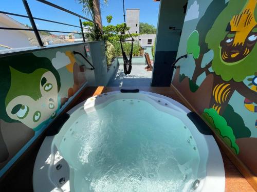 a jacuzzi tub with a painting on the wall at Hospedaria da Lagoa in Florianópolis