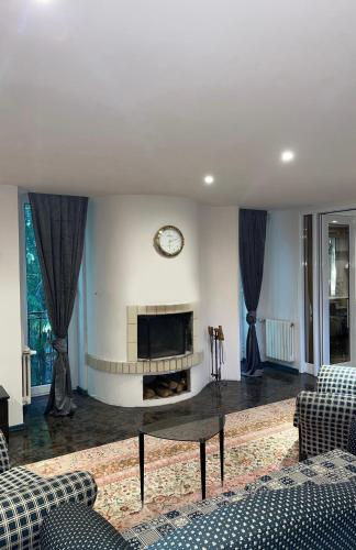 a living room with a fireplace and a clock on the wall at Villa Alexa in Borovets
