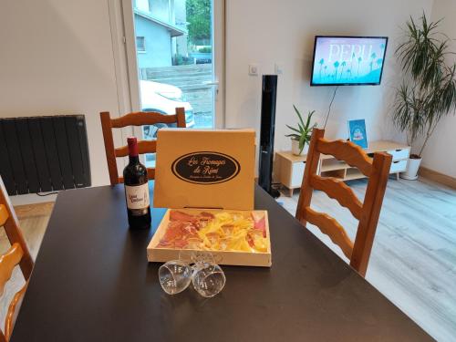 a box of pasta and a bottle of wine on a table at Petit Coin de Bonheur studio Neuf climatisé avec terrasse et parking privé à 5mins du Centre-ville in La Mure