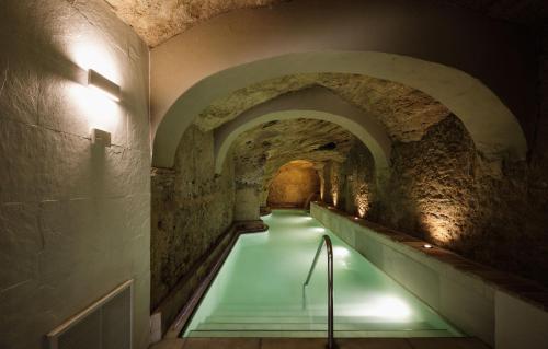 a long tunnel with a green walkway in a castle at Casablanca Vejer Baño Termal in Vejer de la Frontera
