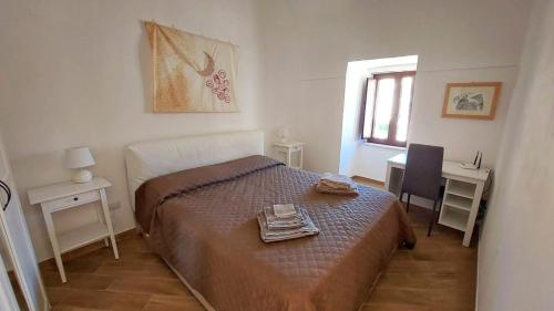 モンテ・サンタンジェロにあるLe Casette nel Rioneのベッドルーム1室(ベッド1台、デスク、窓付)