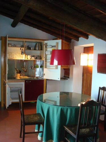 a dining room with a table and a kitchen at Casa Alentejana in Estrela