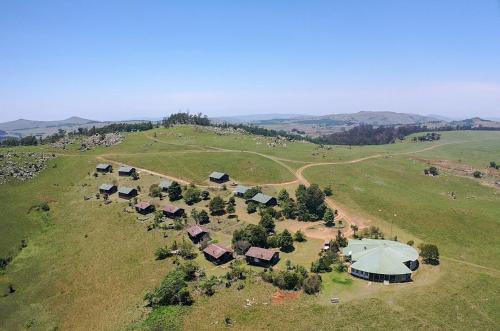 an aerial view of a farm with houses on a hill at Malolotja Log Cabins in Mbabane