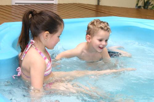 two young children playing in a swimming pool at Hotel Villa Michelon in Bento Gonçalves