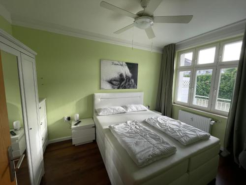 a bedroom with a bed and a ceiling fan at Ferienwohnung Käpt'n Pugs Kajüte auf Rügen in Göhren