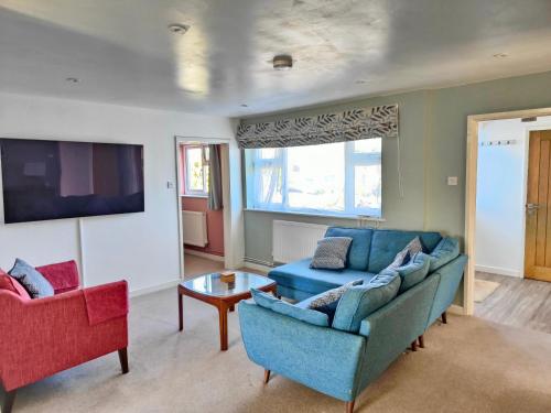 a living room with a couch and two chairs at Seaside bungalow 5 mins walk to beach and town in Bude
