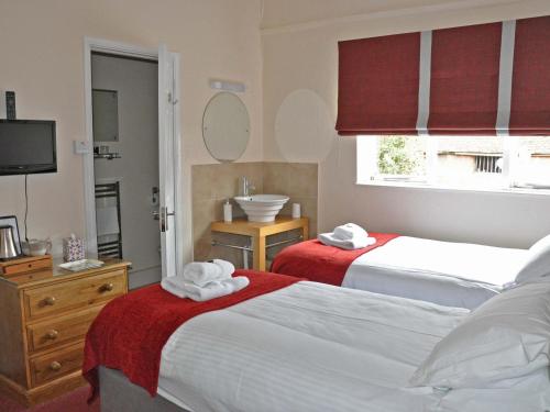 una camera d'albergo con due letti e un lavandino di Rose and Crown a Burwash