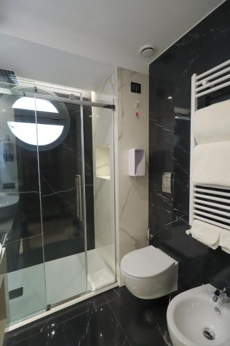 a bathroom with a shower and a toilet and a sink at Hotel Bellavista in Marina di Varcaturo