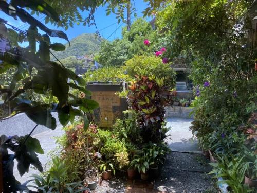 un jardín con muchas plantas y flores en Dosun B&B en Jiufen