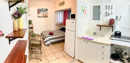 eine kleine Küche mit einem Tisch und einem Bett in der Unterkunft Dotan's Boutique Apartments - By The Beach! in Tel Aviv