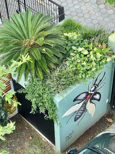 a planter with plants and a bee painted on it at Hospedaria da Lagoa in Florianópolis