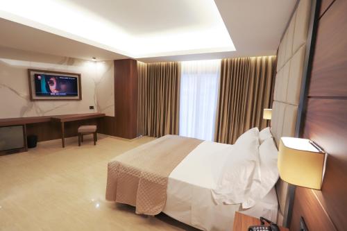 a hotel room with a bed and a flat screen tv at Hotel Bellavista in Marina di Varcaturo