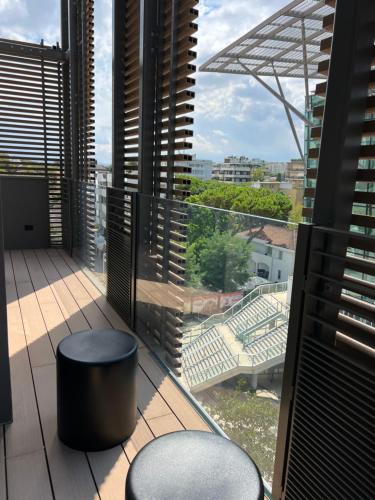 balcón con 2 taburetes y vistas a un estadio en Ceccarini 9 home suite home, en Riccione