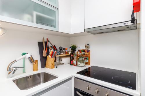 a kitchen with a sink and a stove top oven at Sesimbra Sunshine Cliffs in Sesimbra