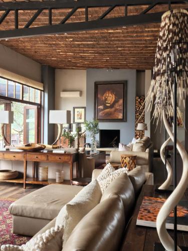 a living room with a leather couch and a table at Karongwe Portfolio - Becks Safari Lodge in Karongwe Game Reserve