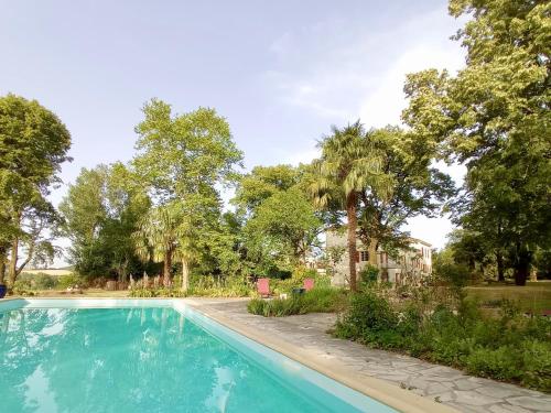 einen Pool in einem Garten mit Bäumen in der Unterkunft Domaine de Rasigous in Saint-Affrique-les-Montagnes