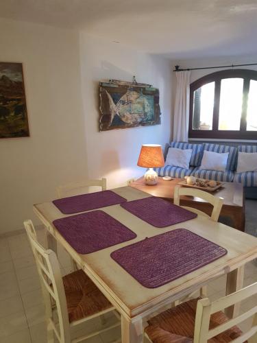 a table with purple mats on it in a living room at Porto Cervo Prestige in Porto Cervo