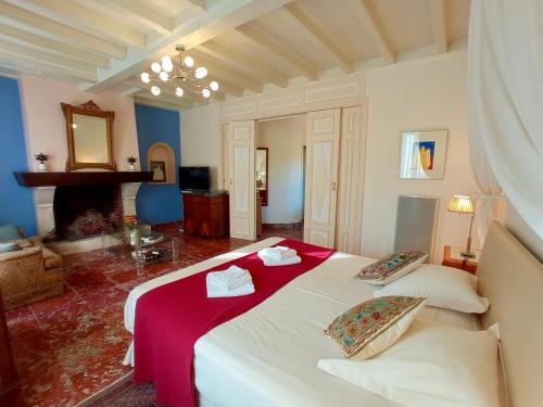 um quarto com uma grande cama branca com lençóis vermelhos em Domaine de Rasigous em Saint-Affrique-les-Montagnes