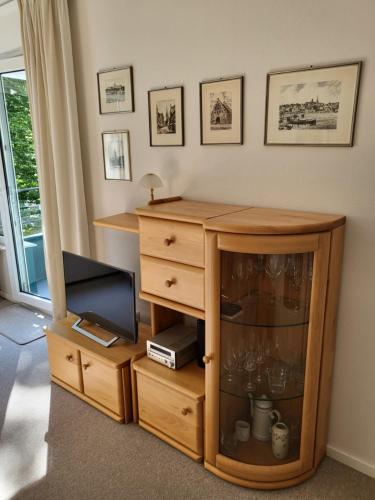 a room with a wooden cabinet and a dresser at Kurpark Appartement in Glücksburg