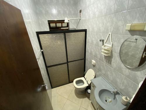bagno con servizi igienici, lavandino e specchio di Casa com Piscina e Churrasqueira a Praia Grande