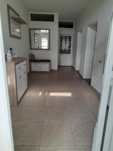 a large kitchen with white cabinets and a tile floor at Apartman Stevan in Pirot