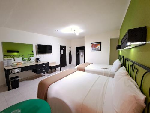 Habitación de hotel con 2 camas y escritorio en Maya Tulipanes Express en Palenque