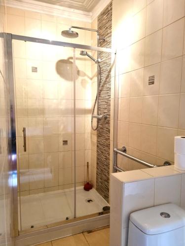 a bathroom with a glass shower with a toilet at Bath Road Studios in Swindon