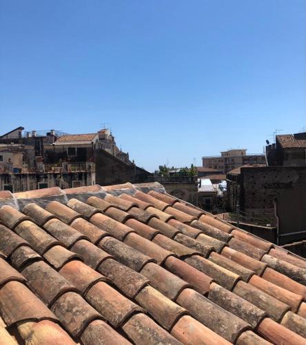 an old tile roof with buildings in the background at Narciso boutique apartment in Acireale