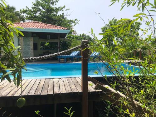 a wooden deck with a rope next to a swimming pool at Atlantis cove Tobago 