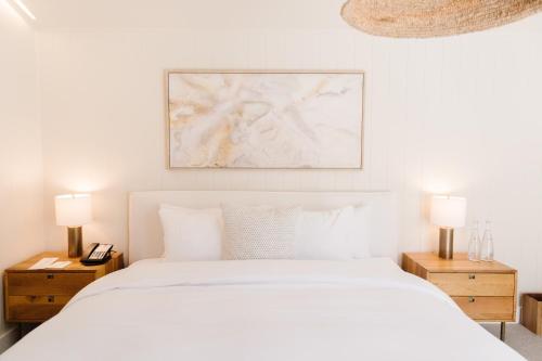 a white bedroom with a white bed and two night stands at Calamigos Guest Ranch and Beach Club in Malibu