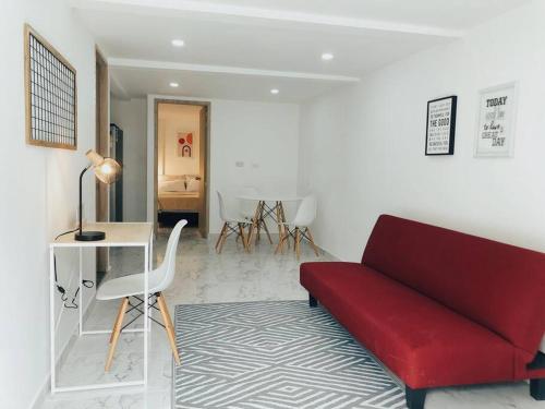 a living room with a red couch and a table at Apartaestudio moderno y acogedor con PARKING in Sabaneta