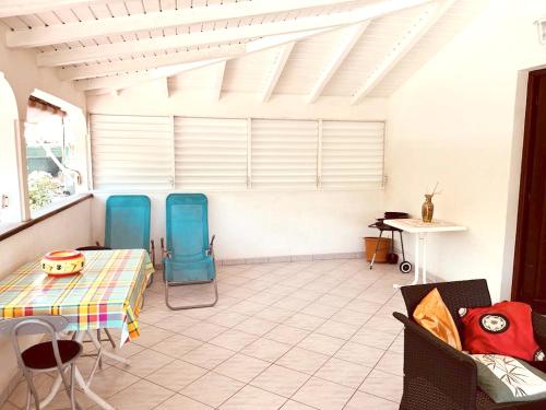 uma sala de estar com duas cadeiras e uma mesa em Villa de 3 chambres avec vue sur la mer jardin clos et wifi a Le Gosier a 2 km de la plage em Le Gosier