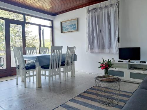 Kampor的住宿－Apartment Riko - accomodation "with" the Adriatic sea，一间配备有白色桌椅的用餐室