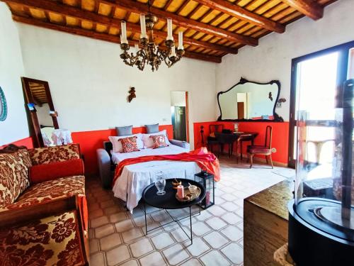 1 dormitorio con cama, sofá y espejo en Cantunera Barbára, en Torre Nubia